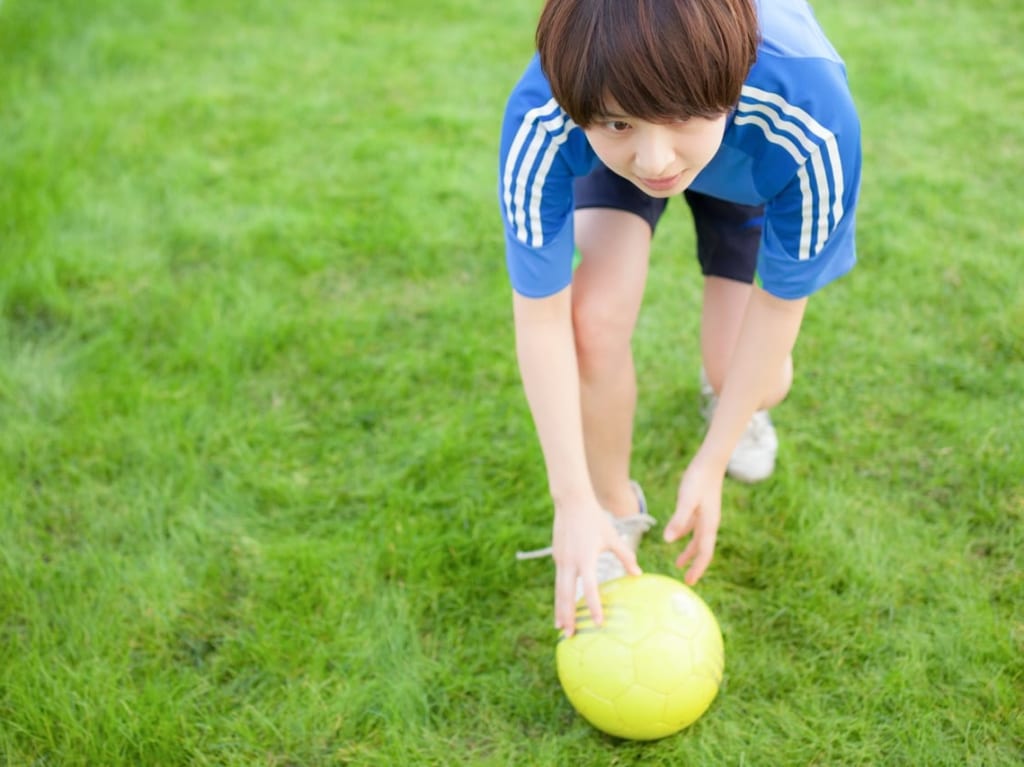 子供がサッカーを蹴る